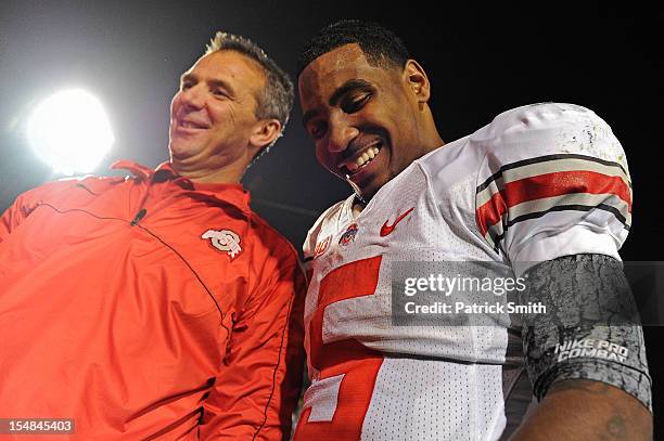 Quarterback Braxton Miller of the Ohio State Buckeyes smiles with head coach Urban Meyer of the Ohio State Buckeyes after defeating the Penn State...