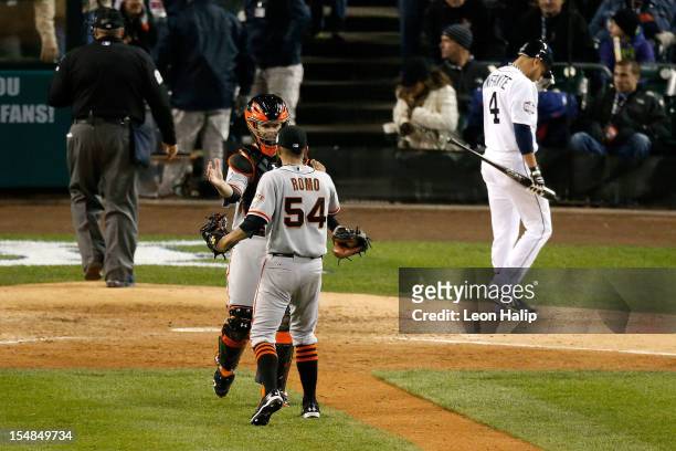 Sergio Romo of the San Francisco Giants celebrates with teammate Buster Posey after striking out Omar Infante of the Detroit Tigers to win Game Three...