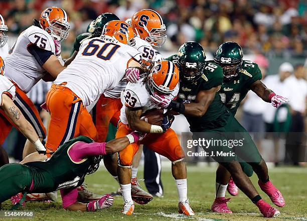 Running back Prince-Tyson Gulley of the Syracuse Orange is tackled by linebacker Sam Barrington of the South Florida Bulls during the game at Raymond...