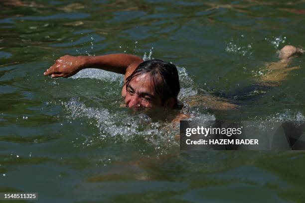 Man swims in spring water during a heatwave near Jerusalem on July 23, 2023.