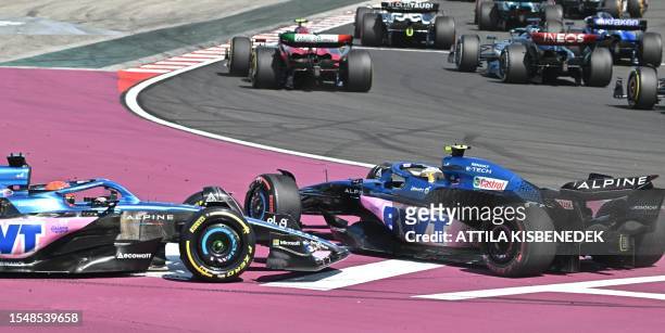 Alpines's French driver Pierre Gasly and Alpine's French driver Esteban Ocon collide as they race during the first lap of the Formula One Hungarian...