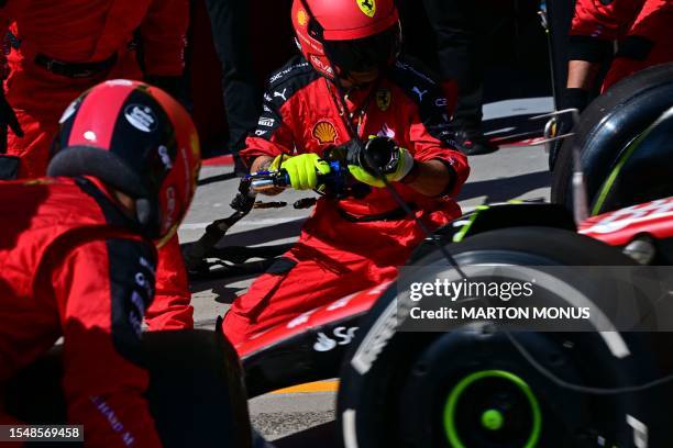 Ferrari's Spanish driver Carlos Sainz gets new tires in the pits during the Formula One Hungarian Grand Prix at the Hungaroring race track in...
