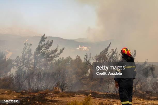 Firefighters try to extinguish wildfires in Asklipio village on Rhodes island, Greece on July 23, 2023. Some 19,000 people have been evacuated from...