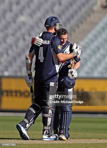 David Hussey of the Bushrangers celebrates his century with Andrew Mcdonald during the Ryobi One Day Cup match between Victorian Bushrangers and the...