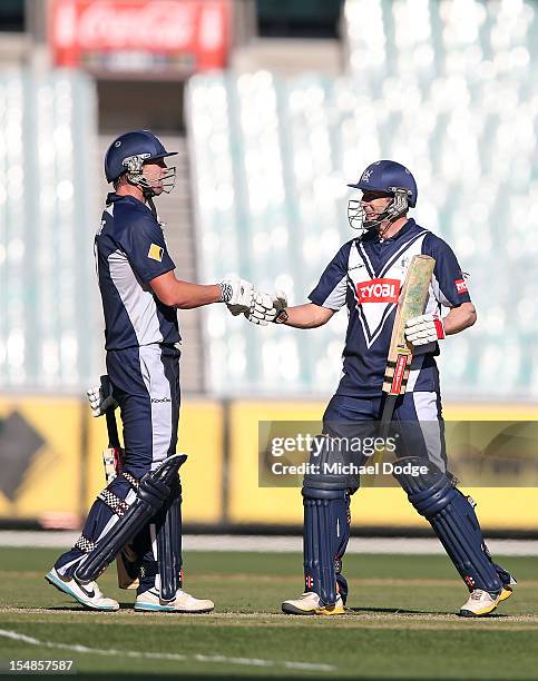 Cameron White and David Hussey of Bushrangers celebrate their century partnership during the Ryobi One Day Cup match between Victorian Bushrangers...