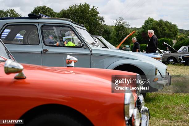 Enthusiasts look at the engines of classic cars during the annual classic car and motorcycle show on July 16, 2023 in Dudswell, near Berkhamsted,...