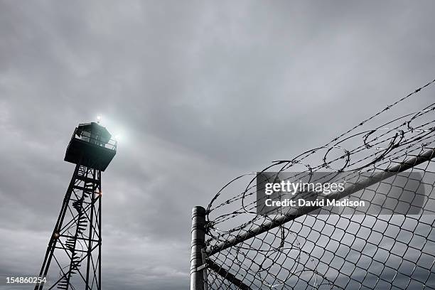 security tower and razor wire-topped  fence - prison ストックフォトと画像