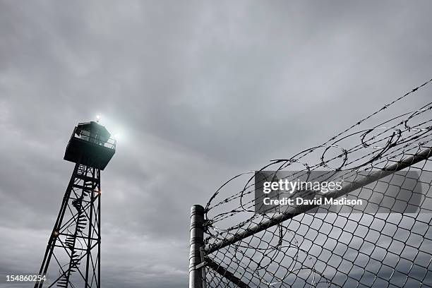 security tower and razor wire-topped  fence - jail stock pictures, royalty-free photos & images