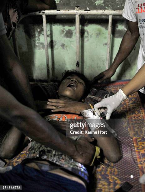 Tun Tun,a 17yrs old Buddhist Rakhine, has his gun shot wound treated in Kyauk Taw township hospital on October 25, 2012 in Kyauk Taw, Myanmar. Over...