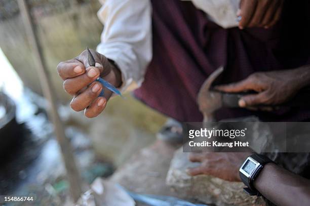 Rakhine men make Jingali, a local handmade weapon for shooting, outside the jetty on October 27, 2012 in Sittwe, Myanmar. Over twenty thousand people...