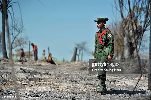 Soldier stands guard at quarter No.3 in Pauktaw township, that was burned in recent violence between Buddhist Rakhine and Muslim Rohingya, on October...