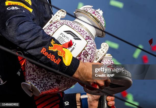 Max Verstappen on the podium with his broken trophy after winning the Hungarian Grand Prix at the Hungaroring. ANP REMKO DE WAAL