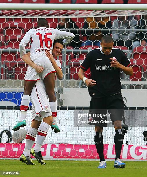 Christian Gentner of Stuttgart celebrates his team's first goal with team mate Ibrahima Traore as Bamba Anderson of Frankfurt reacts during the...