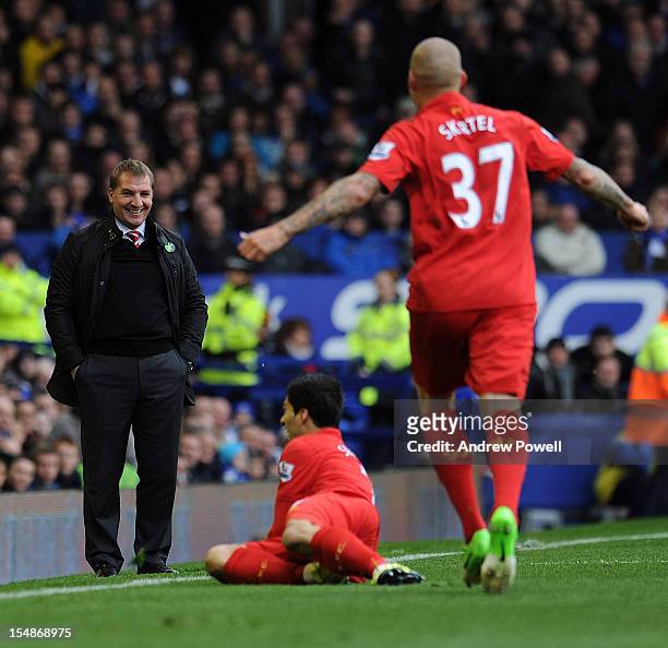 Liverpool manager Brendan Rodgers smiles as he watches Luis Suarez of Liverpool celebrate after scoring the opening goal during the Barclays Premier...