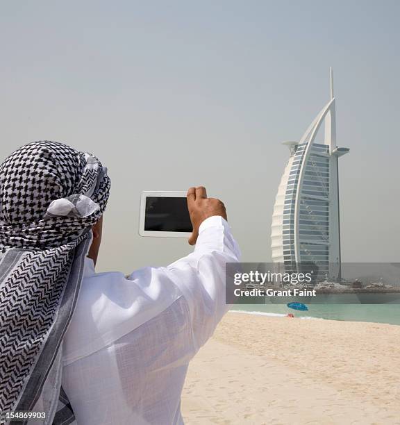 arab man photographing building. - ghoutra stock pictures, royalty-free photos & images