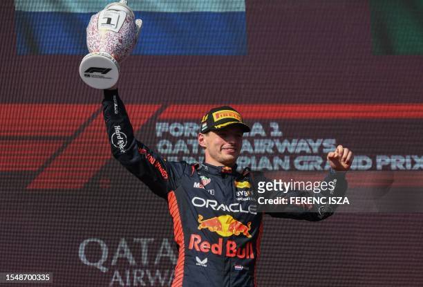 Red Bull Racing's Dutch driver Max Verstappen celebrates on the podium after the Formula One Hungarian Grand Prix at the Hungaroring race track in...