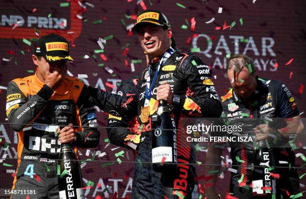 Second placed McLaren's British driver Lando Norris and winner Red Bull Racing's Dutch driver Max Verstappen celebrate on the podium with Champagne...
