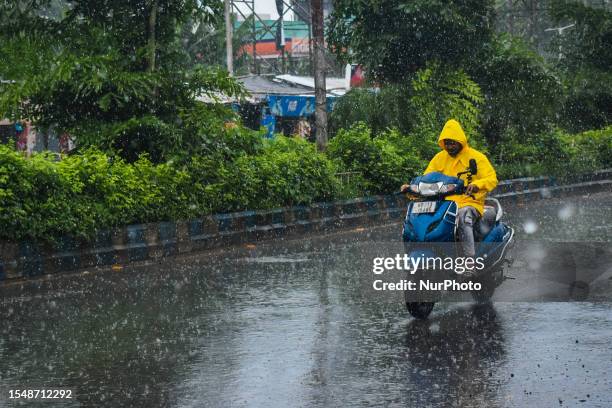 Person rides a scooter through a road as it rain in Kolkata, India on 23 July 2023.