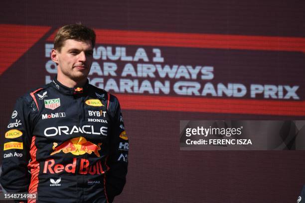 Red Bull Racing's Dutch driver Max Verstappen stands on the podium after winning the Formula One Hungarian Grand Prix at the Hungaroring race track...