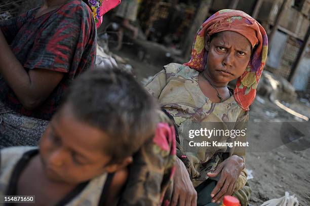 Mother and child, displaced by the recent violence between Buddhist Rakhine and Muslim Rohingya in Kyuk Phyu township, sit on the ground after...