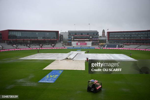 Covers remain on the wicket as puddles form on the outfield delaying the start of play on day five of the fourth Ashes cricket Test match between...