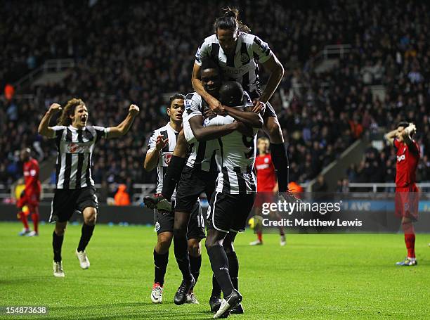 Papiss Demba Cisse of Newcastle United is congratulated by team mates on his goal during the Barclays Premier League match between Newcastle United...