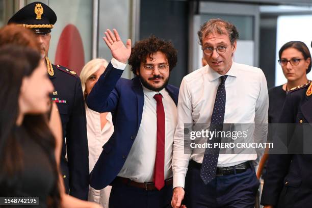 Egyptian activist Patrick Zaki waves as he walks next to the rector of the University of Bologna, Giovanni Molari, upon his arrival at Malpensa...