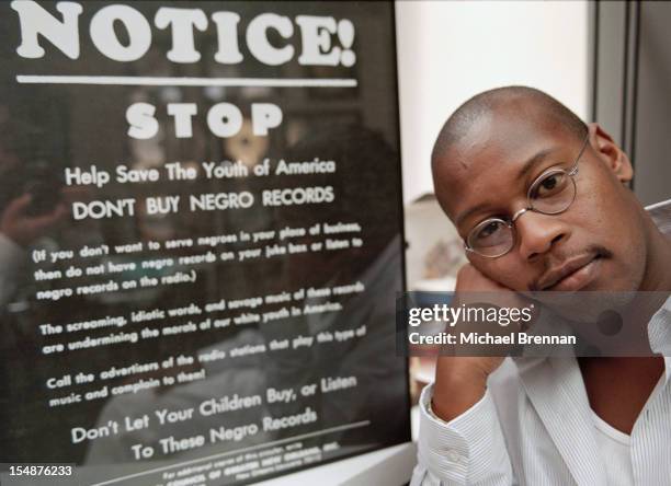 American hip hop artist Andre Harrell, founder of record label Uptown Records, New York City, 1996. Next to him is a sign reading 'Notice! Stop. Help...