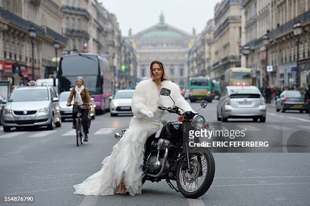 Model presents a wedding dress of Metal Flaque on October 26, 2012 in front of the Opera on October 26, 2012 in Paris. From "Kate"-inspired lace...