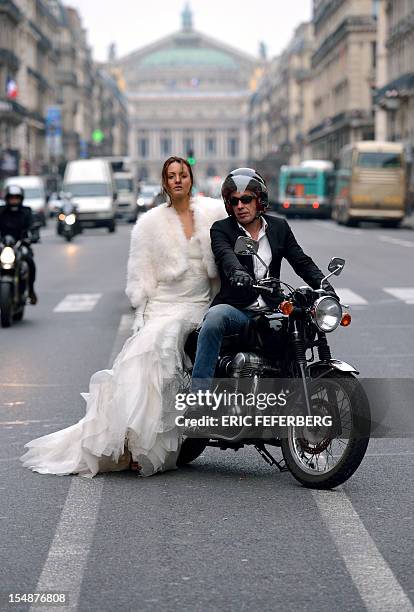 Model poses on a motorcycle on the Avenue de l'Opera as she presents a wedding dress of Metal Flaque on October 26, 2012 in Paris. From...