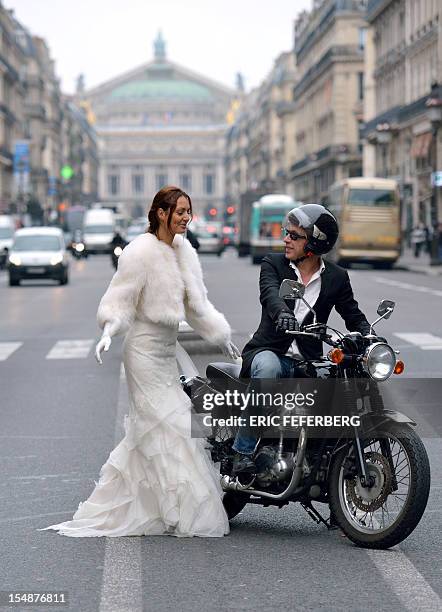 Model poses on a motorcycle on the Avenue de l'Opera as she presents a wedding dress of Metal Flaque on October 26, 2012 in Paris. From...