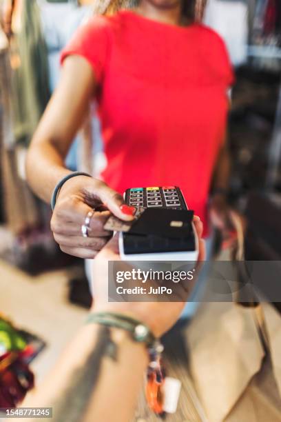 young adult african woman shopping and paying for the purchase by credit card - card reader stock pictures, royalty-free photos & images