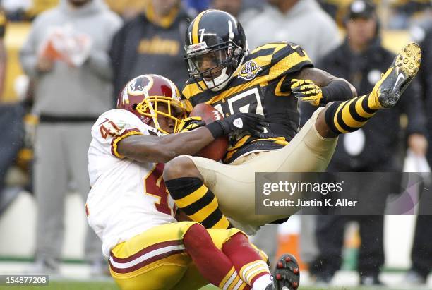 Mike Wallace of the Pittsburgh Steelers makes a catch and is hit by Madieu Williams of the Washington Redskins during the game on October 28, 2012 at...