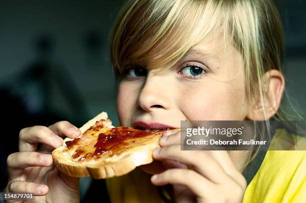 young girl eating toast with jam - nottinghamshire stock pictures, royalty-free photos & images