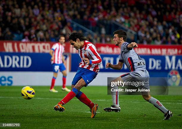 Falcao of Club Atletico de Madrid strikes to score besides Oier Sanjurjo of Osasuna during the La Liga match between Club Atletico de Madrid and CA...