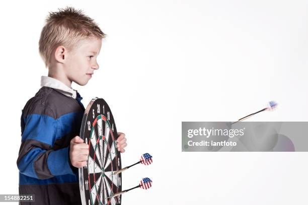 young boy with dartboard looking an us dart - chilldren stock pictures, royalty-free photos & images