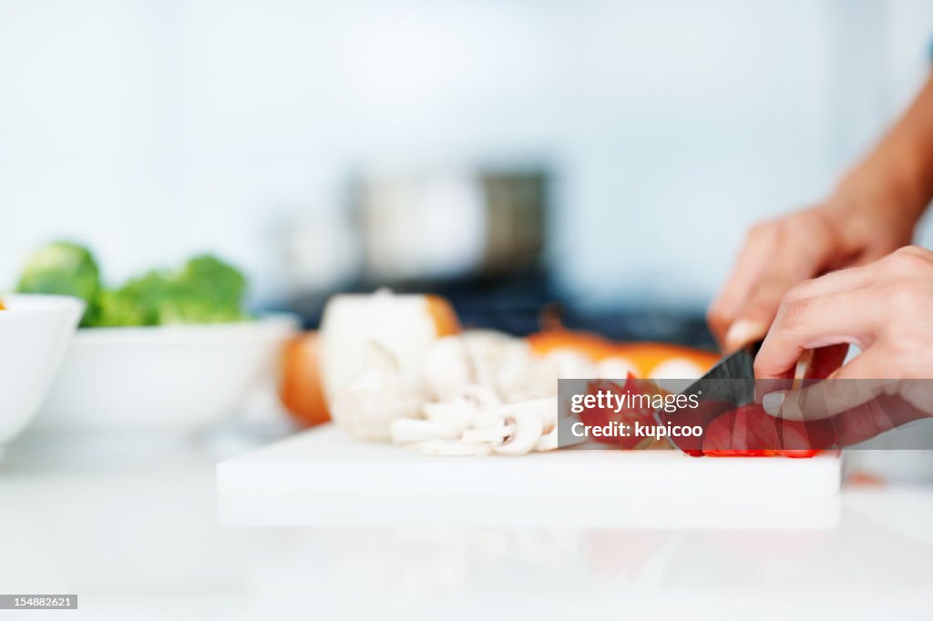 Closeup of hands chopping vegetables in the kitchen