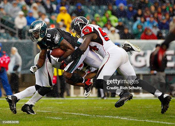 Wide receiver Jeremy Maclin of the Philadelphia Eagles makes a catch and is tackled by Dunta Robinson and Stephen Nicholas of the Atlanta Falcons...