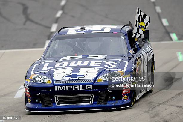 Jimmie Johnson, driver of the Lowe's Chevrolet, celebrates with the checkered flag after winning the NASCAR Sprint Cup Series Tums Fast Relief 500 at...