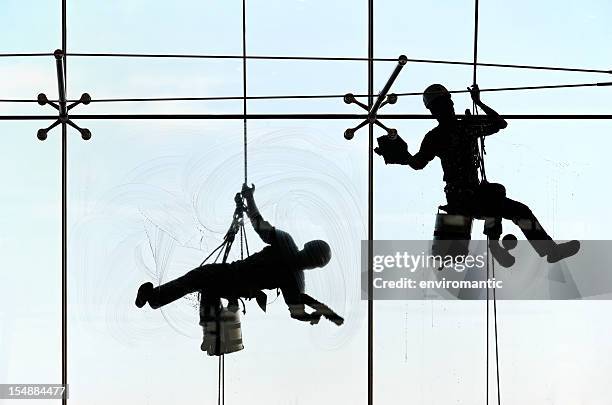 high-rise window cleaners. - facade cleaning stock pictures, royalty-free photos & images