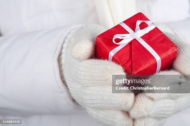 small red christmas present in palm - red glove stock pictures, royalty-free photos & images