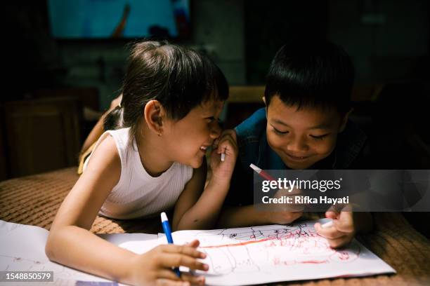 happy asian kids colouring a drawing book together at home. - adult coloring stock pictures, royalty-free photos & images