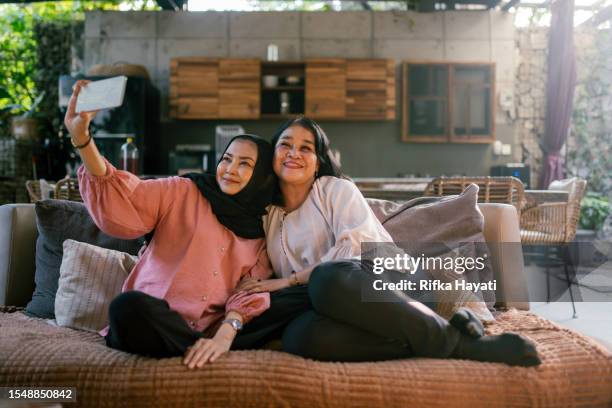 seniorin und ihre freundin halten den moment fest, indem sie gemeinsam ein selfie machen. - indonesischer archipel stock-fotos und bilder