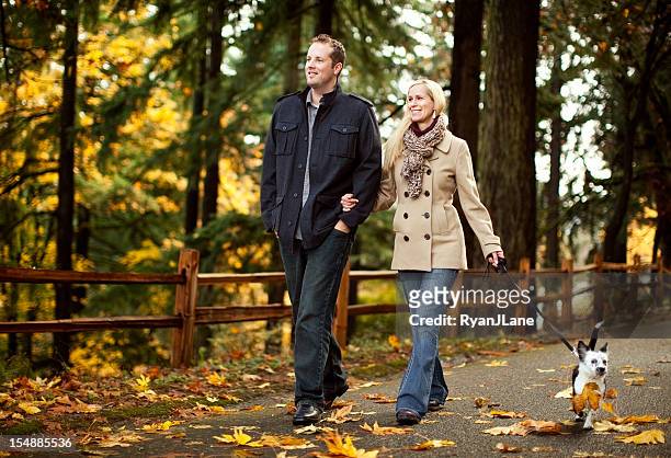 joven pareja caminando perro en otoño las hojas - chaquetón marinero fotografías e imágenes de stock