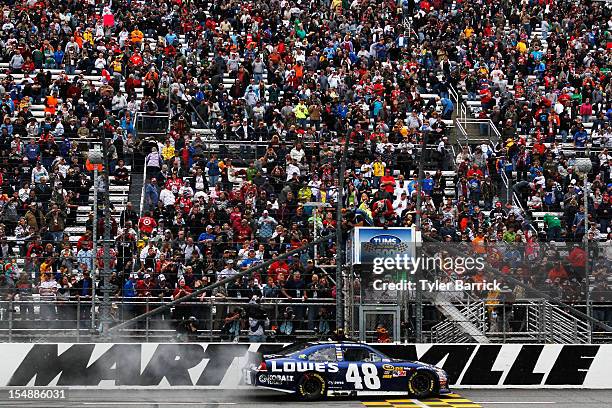 Jimmie Johnson, driver of the Lowe's Chevrolet, celebrates after winning the NASCAR Sprint Cup Series Tums Fast Relief 500 at Martinsville Speedway...