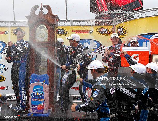 Jimmie Johnson, driver of the Lowe's Chevrolet, celebrates with crew chief Chad Knaus and crew members in Victory Lane after winning the NASCAR...