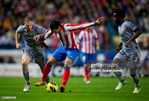 Falcao of Club Atletico de Madrid duels for the ball with Fernando Da Silva and Anthony Annan of Osasuna during the La Liga match between Club...