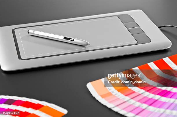 graphic designer's tools: digital tablet, pen, swatches, dark gray background - grafisch ontwerpbureau stockfoto's en -beelden