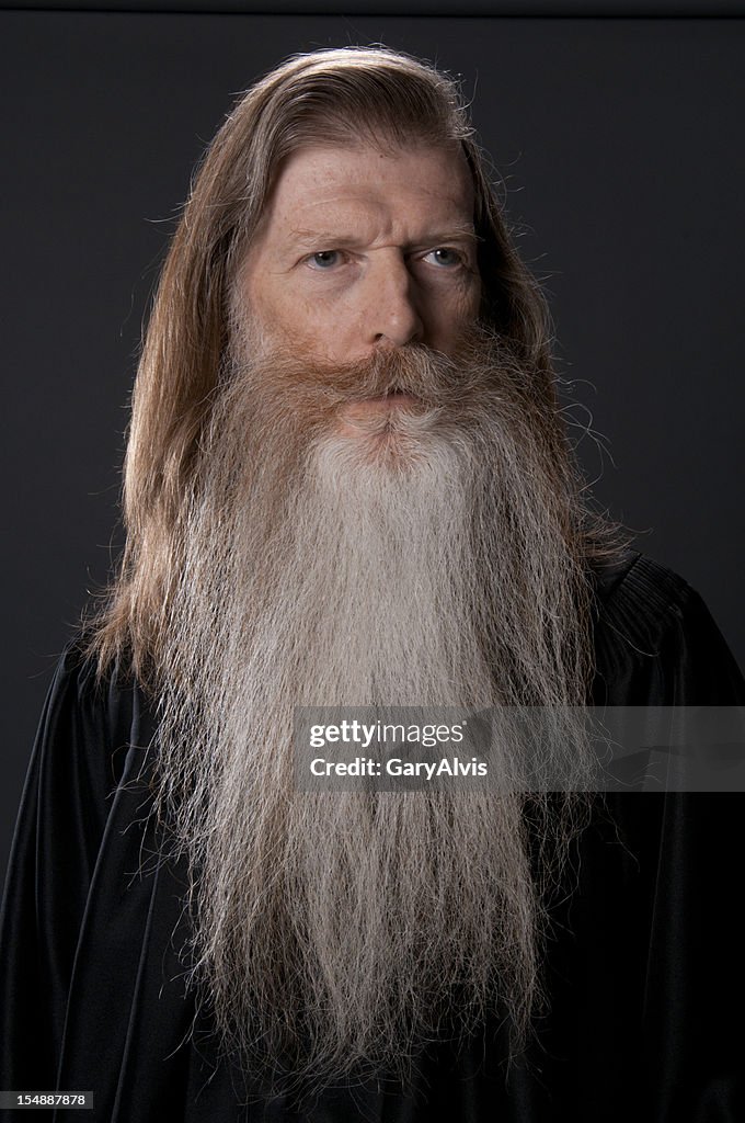 Full face of long bearded man in black robe-isolated