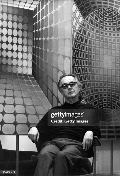 Hungarian born French artist Victor Vasarely poses in front of one of his Op Art paintings, c. 1978.